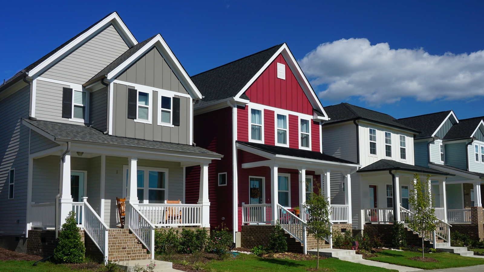 Row of single-family homes with front porches on a residential street